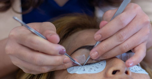 Close-up of beautician giving beauty treatment to customer