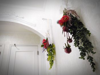 Flower vase against white house door