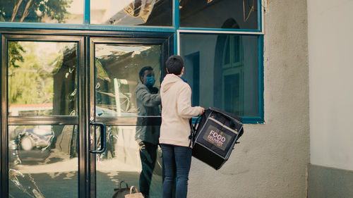 Rear view of man standing against wall