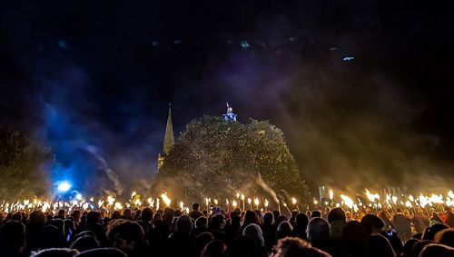 Crowd at music concert against sky at night