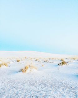 View of sand dune against blue sky