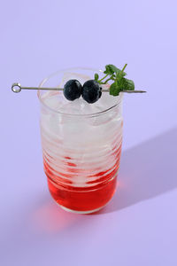 Blueberry sparkling red mojito isolated on purple background. summer fresh drink