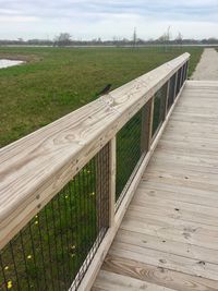 Wooden fence on field against sky