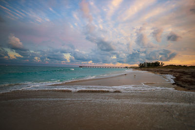 Scenic view of beach against sky during sunset