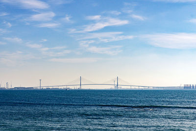 Suspension bridge over sea against sky