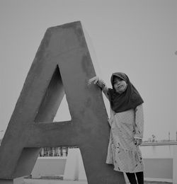 Portrait of woman standing against wall