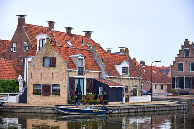 Historic house on a canal in makkum boy the ijsselmeer with a small motor boat in the water