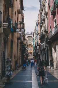 People on street amidst buildings in city