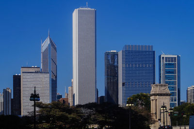 Low angle view of skyscrapers against clear blue sky