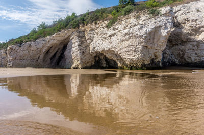 Scenic view of rock formation in lake against sky