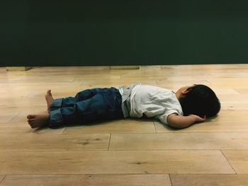 Side view of baby sleeping on floor at home