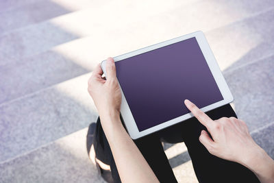 Low section of woman using mobile phone