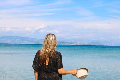 Rear view of woman looking at sea against sky