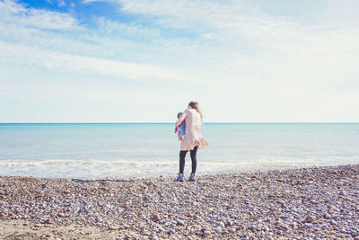 Full length of man standing at beach against sky