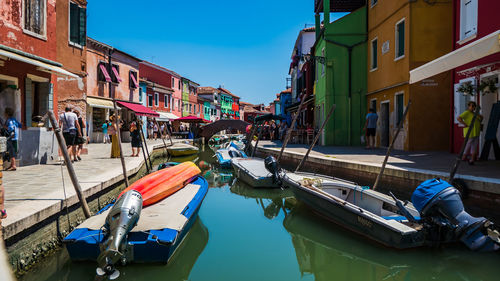 Boats moored in canal along city