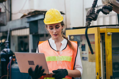 Young engineer using laptop at factory