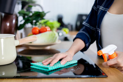 Midsection of woman using mobile phone on table