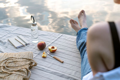 Summer picnic by the lake at sunset. woman relaxes in nature.