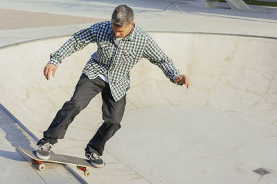 Man skateboarding on ramp in park