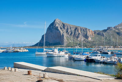 Sailboats moored in harbor