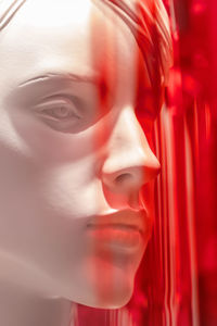 Close-up of mannequin against red decoration