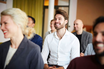 Smiling entrepreneurs sitting in conference meeting at workplace