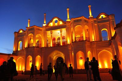 People in illuminated building at night