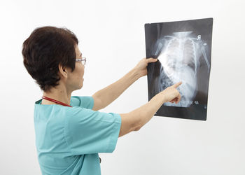 Doctor examining x-ray image against white background