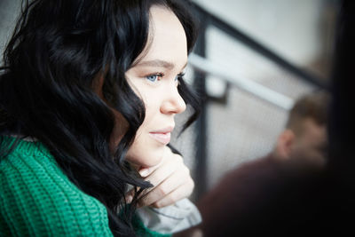 Close-up of young woman with black hair looking away in university