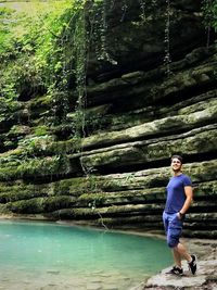 Full length of young man looking at waterfall