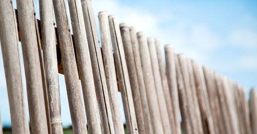 Low angle view of wooden fence against sky
