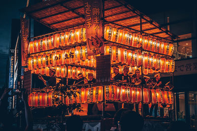 Illuminated lanterns hanging in building at night