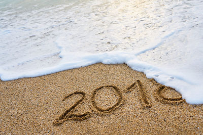 High angle view of text on sand at beach