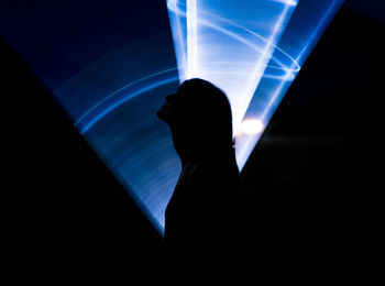 Silhouette person with illuminated light painting at night