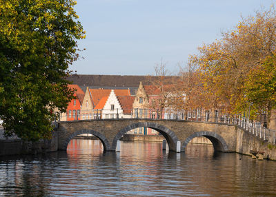 Arch bridge over river against sky