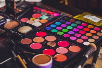 Close-up of multi colored makeup box on table