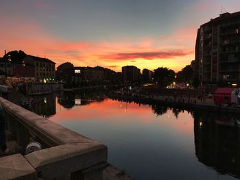 Reflection of buildings in city at sunset