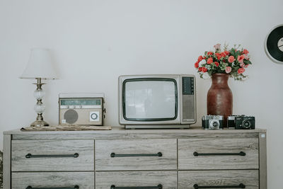 An old radio, tv and potted plant on table