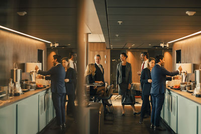 Male and female legal colleagues talking during coffee break in office canteen