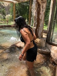 Woman wearing swimwear while standing in water at resort