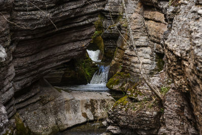 Low angle view of waterfall amidst rocks