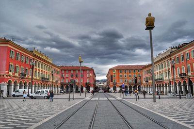 View of city street against cloudy sky