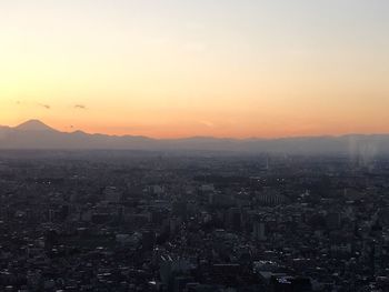 Aerial view of city buildings against sky during sunset