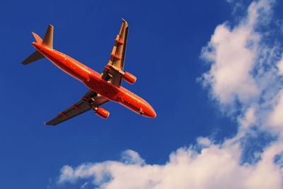 Low angle view of airplane flying against sky