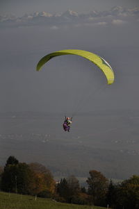 Person paragliding against sky