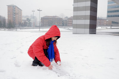 Smiling woman playing in snow during winter