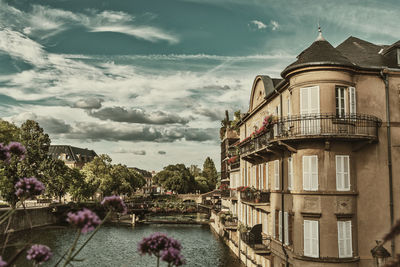 View of building by canal against sky