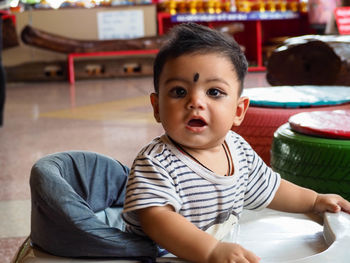 Portrait of cute baby boy standing in walker