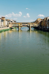 Ponte vecchio over arno river against sky