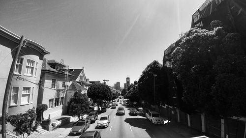 Cars on road against sky in city